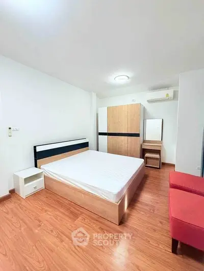 Spacious bedroom with modern furniture and wooden flooring