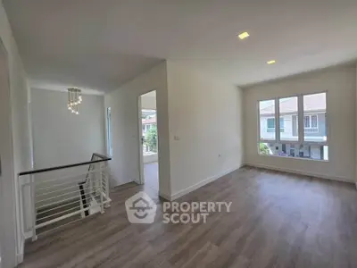 Spacious and bright living area with modern flooring and large windows in a contemporary home.