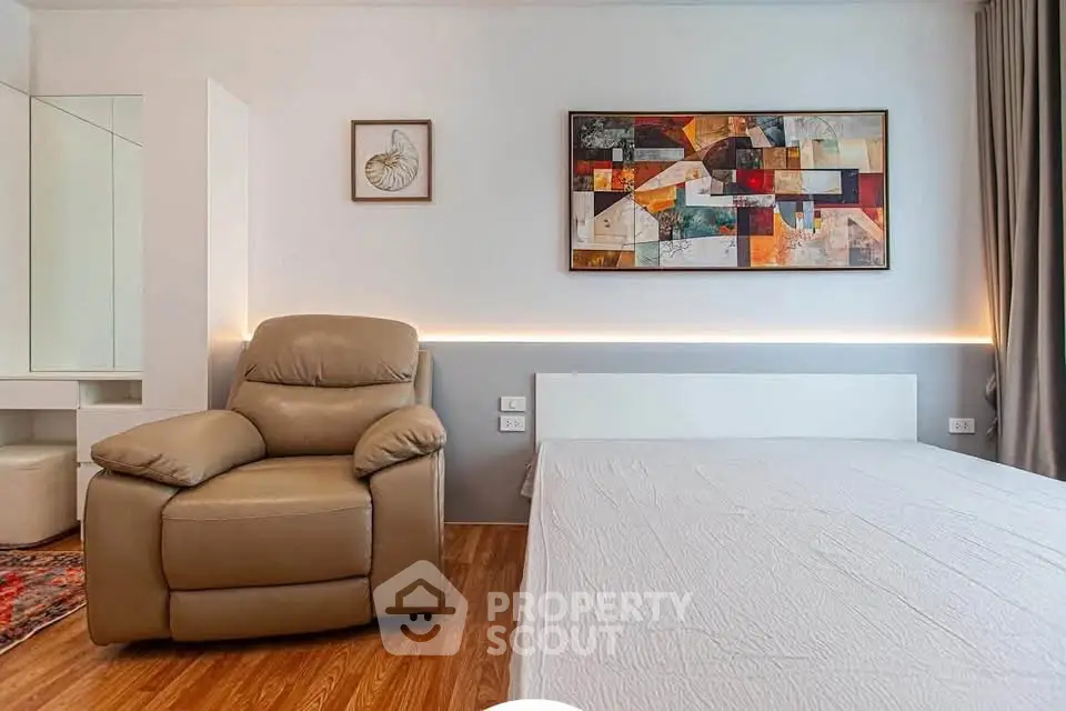 Modern bedroom with stylish decor and comfortable seating in a contemporary apartment.