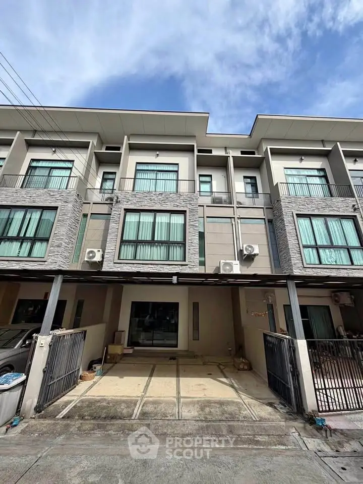 Modern townhouse exterior with large windows and garage space