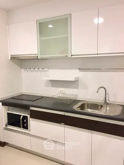 Modern kitchen with sleek white cabinetry and built-in appliances