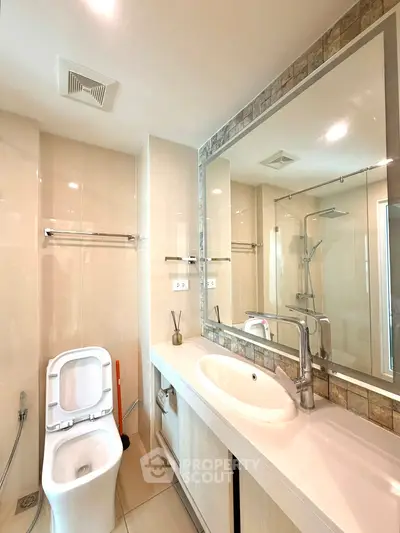 Modern bathroom with sleek fixtures and large mirror