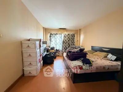 Spacious bedroom with wooden flooring and ample natural light, ideal for cozy living.