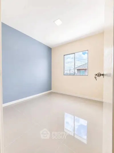 Bright empty room with glossy tiled floor and large window, perfect for customization.