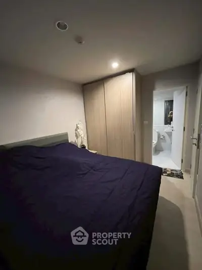 Cozy bedroom with modern design and ensuite bathroom in a stylish apartment.