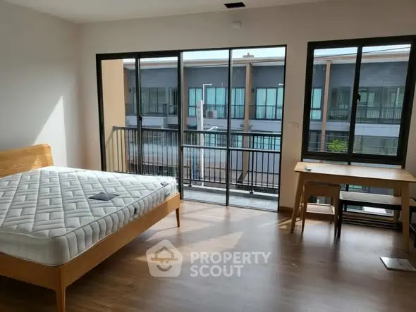 Spacious bedroom with balcony and natural light in modern apartment