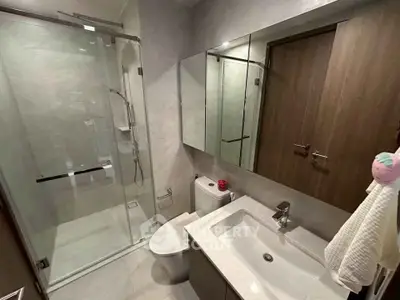 Modern bathroom with glass shower and sleek fixtures in a contemporary apartment.