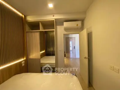 Modern bedroom with built-in wardrobe and air conditioning in a stylish apartment.