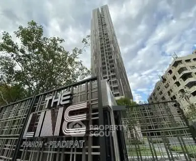 Modern high-rise condominium with sleek design and lush greenery at The Line Phahon-Pradipat.