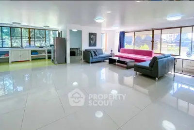 Spacious living room with modern sofas and large windows offering natural light.