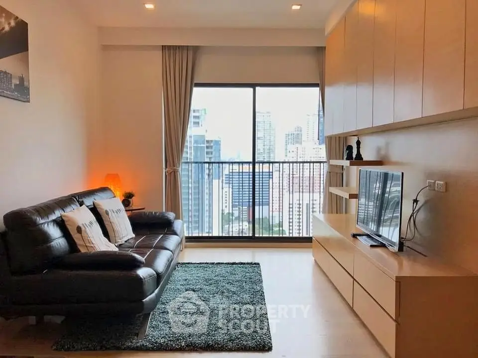 Modern living room with city view, featuring sleek leather sofa and built-in entertainment unit.