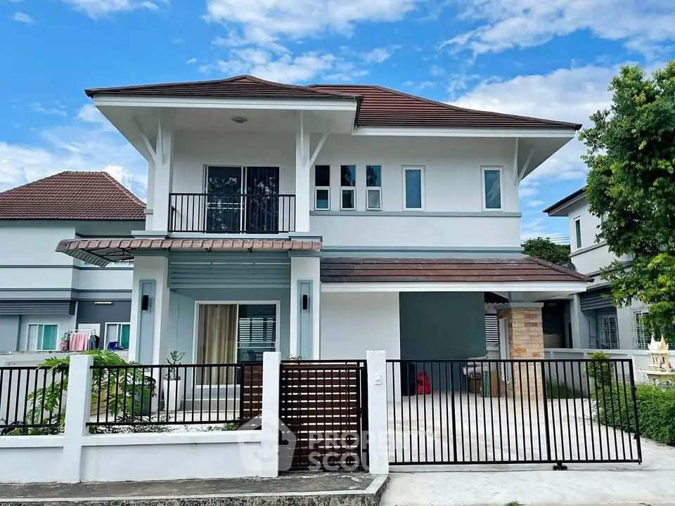 Modern two-story house with a gated front yard and stylish architecture.