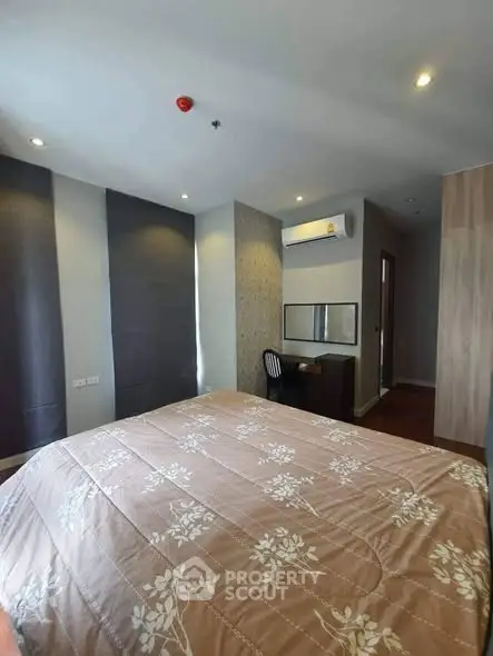 Spacious bedroom with modern decor and natural light in a stylish apartment.