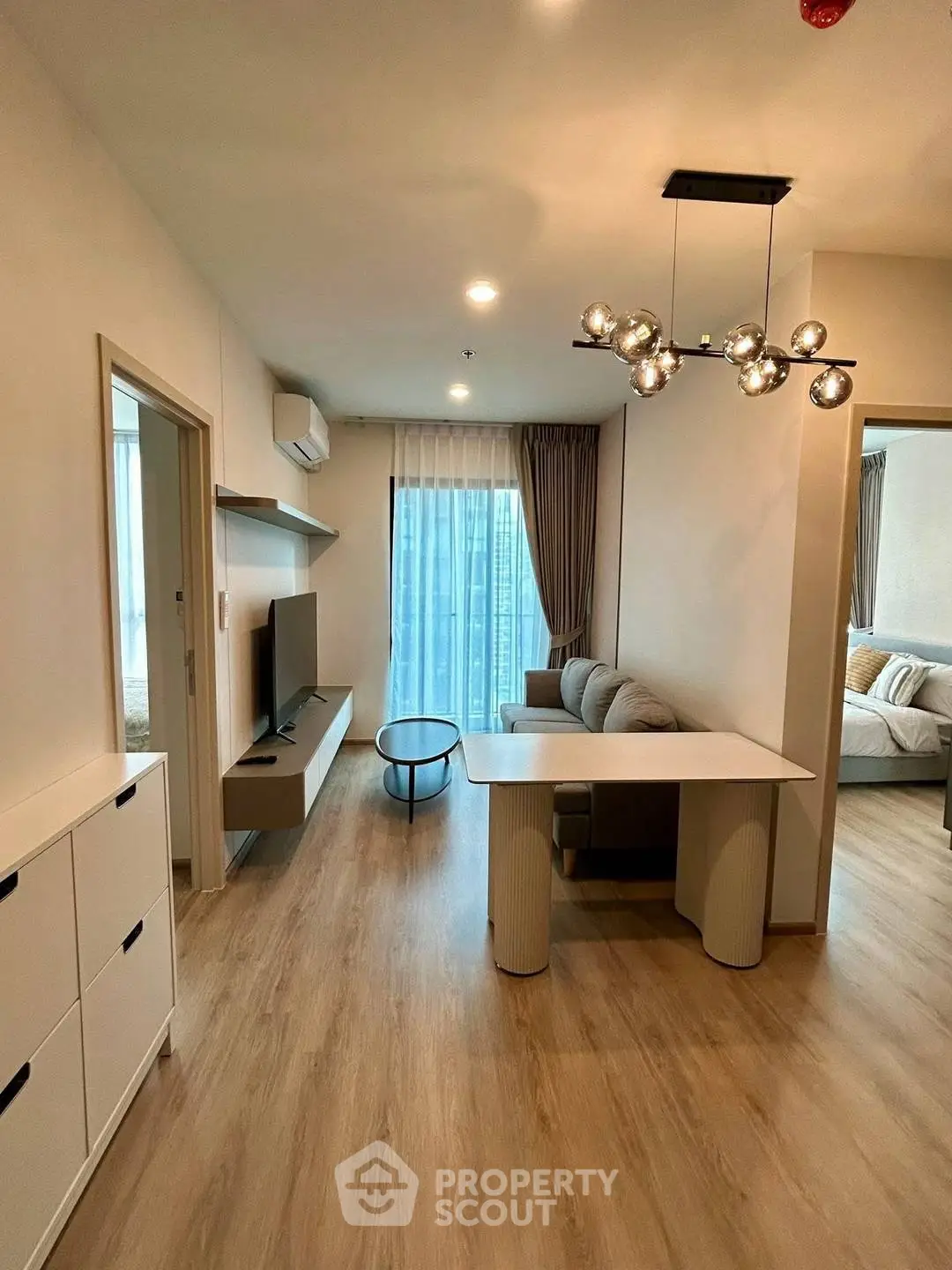 Modern living room with stylish furniture and open layout, featuring a cozy sofa and elegant lighting.