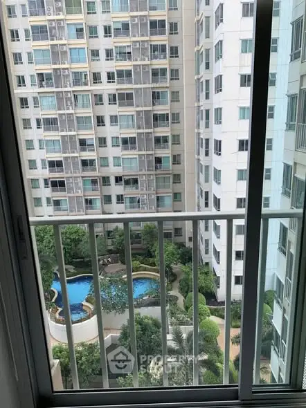 High-rise apartment view with pool and garden from balcony