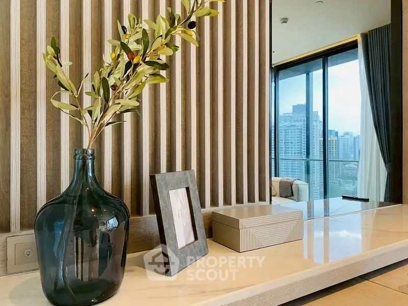 Modern interior with elegant decor and city view from large windows.