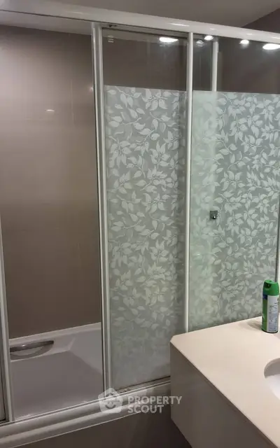 Modern bathroom with elegant frosted glass shower doors and sleek countertop