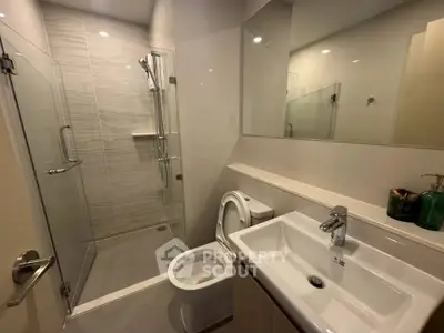 Modern bathroom with glass shower and sleek fixtures in a contemporary apartment.