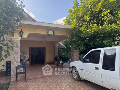 Charming suburban home with spacious driveway and lush greenery, perfect for family living.