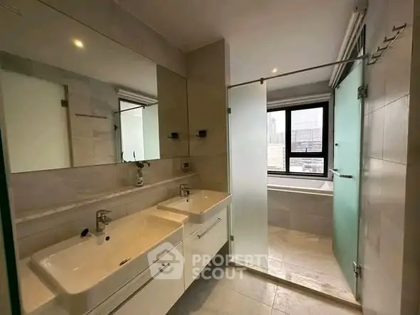Modern bathroom with dual sinks and glass shower enclosure