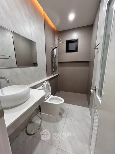 Modern bathroom with sleek design, featuring a stylish sink and shower area.
