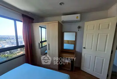 Cozy bedroom with city view, featuring a wardrobe, dressing table, and air conditioning.