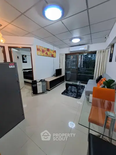 Modern living room with sleek furniture and large window offering natural light.