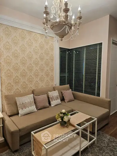 Elegant living room with chandelier and stylish sofa in cozy apartment