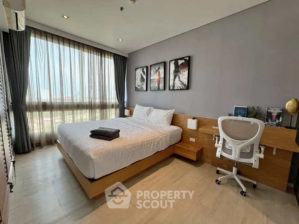 Modern bedroom with stylish decor and large window offering natural light