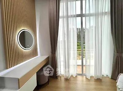 Elegant bedroom with modern vanity and large window overlooking balcony