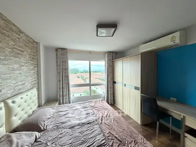 Spacious bedroom with modern decor and scenic window view in a stylish apartment.