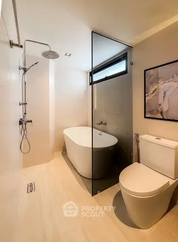 Modern bathroom with sleek design, featuring a freestanding bathtub and rainfall shower.