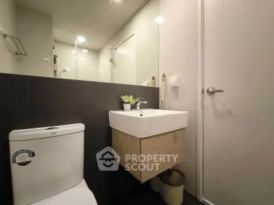 Modern bathroom with sleek fixtures and minimalist design, featuring a floating vanity and contemporary toilet.