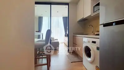 Modern kitchen with washing machine and open layout to living area