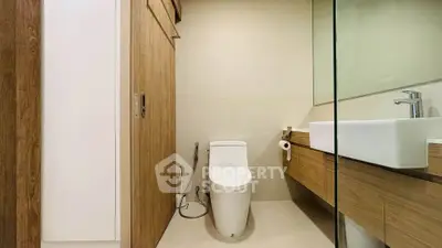 Modern bathroom with sleek wooden cabinetry and contemporary fixtures.