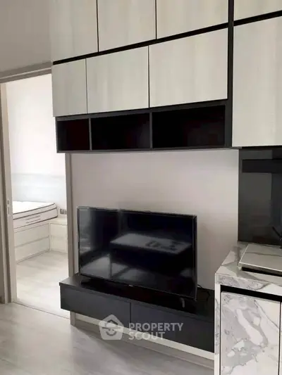 Modern living room with sleek cabinetry and flat-screen TV, showcasing contemporary interior design.