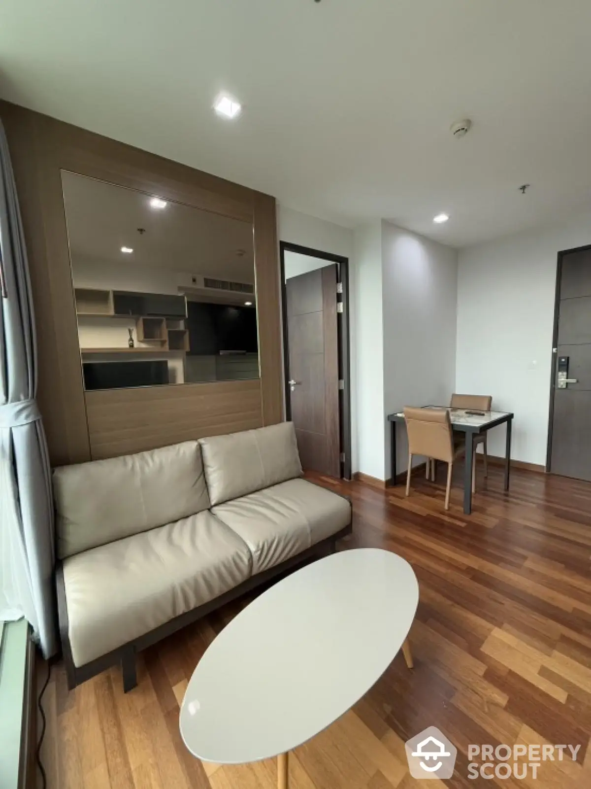 Modern living room with wooden flooring and sleek furniture in a stylish apartment.