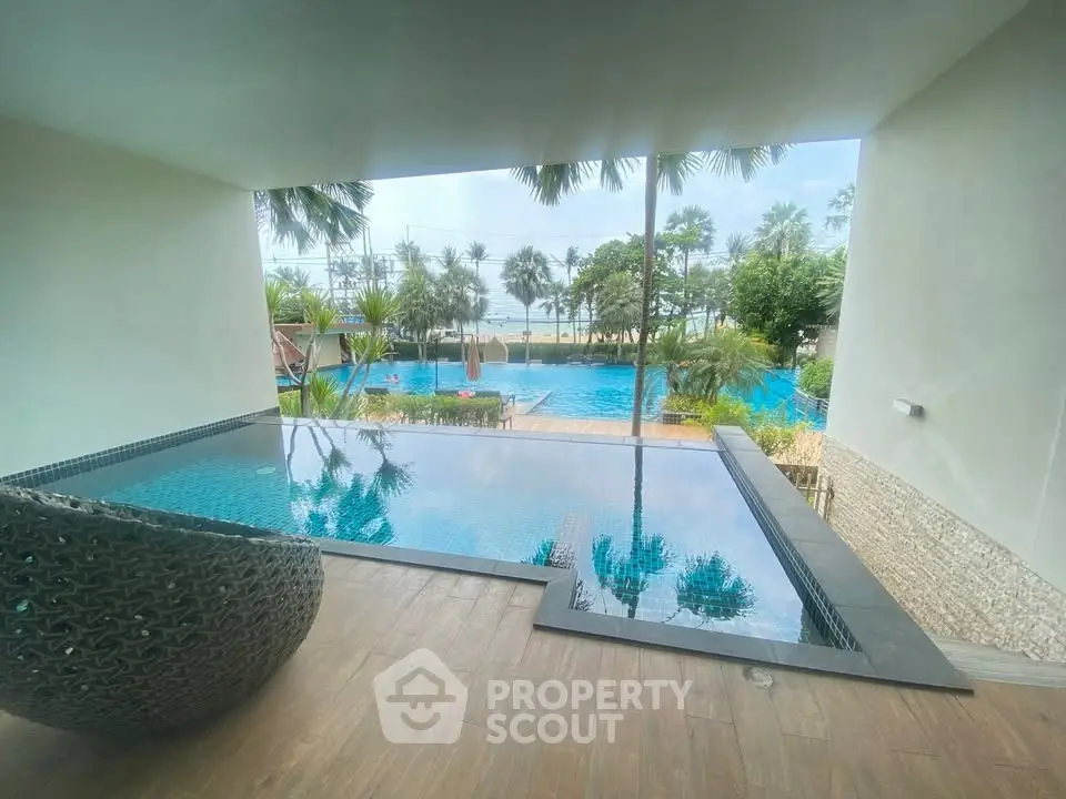Luxurious poolside view with palm trees and ocean backdrop, perfect for relaxation and leisure.