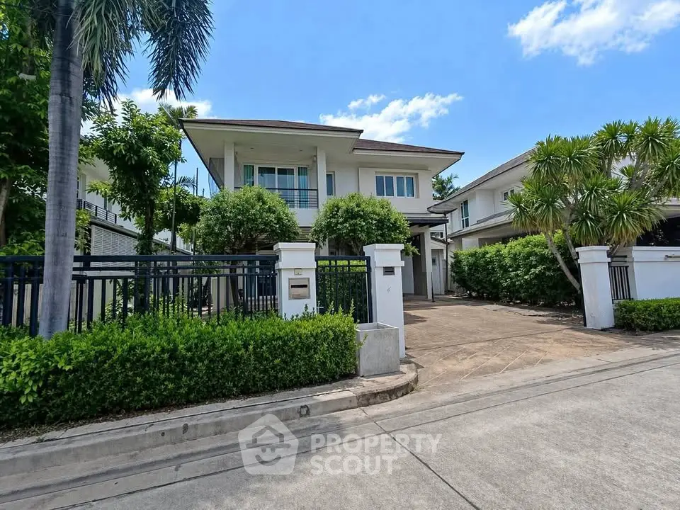 Stunning modern house with lush greenery and spacious driveway in a serene neighborhood.