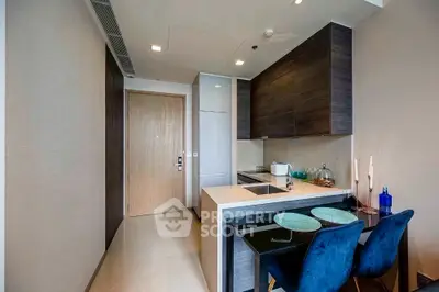 Modern kitchen with sleek cabinetry and dining area in a stylish apartment.