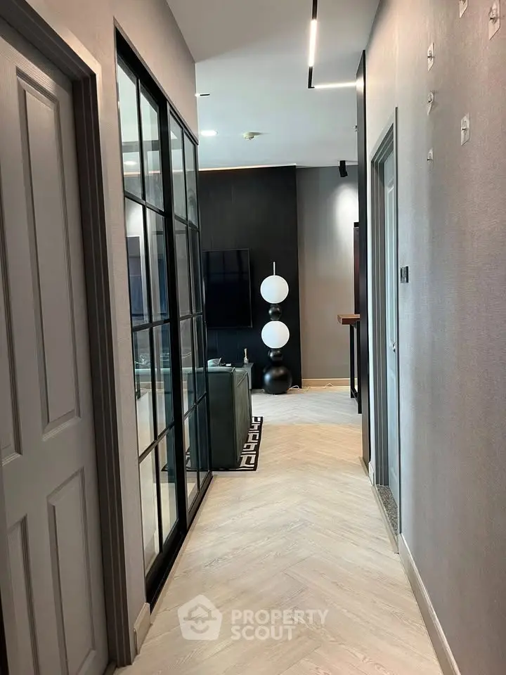 Stylish modern hallway leading to a chic living room with elegant decor and sleek flooring.