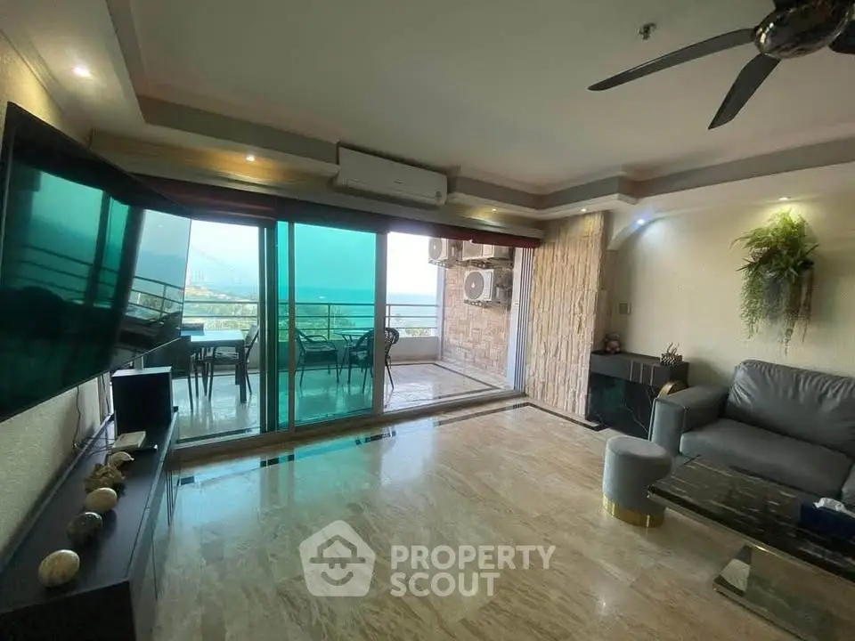 Luxurious living room with large balcony and stunning view, featuring modern decor and ample natural light.