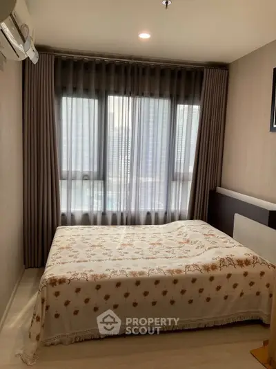 Cozy bedroom with large window and elegant curtains in modern apartment