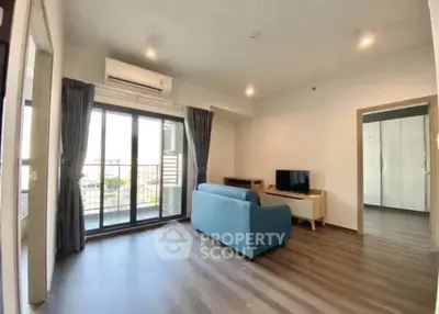 Spacious living room with modern decor and balcony access in a stylish apartment.
