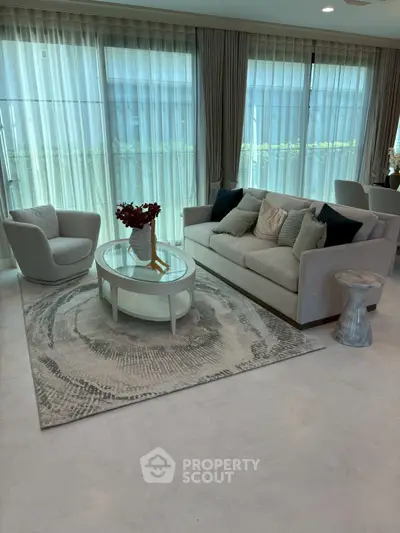 Elegant living room with modern furniture and large windows, perfect for relaxation and entertaining.