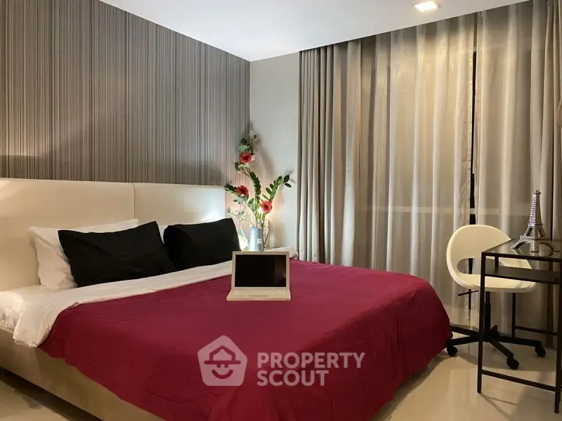 Modern bedroom with stylish decor and workspace, featuring a cozy bed and elegant lighting.