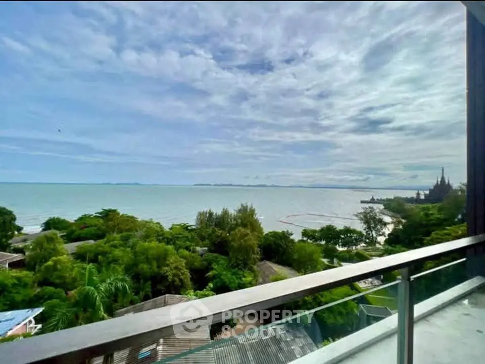 Stunning ocean view from a modern balcony overlooking lush greenery and serene coastline.