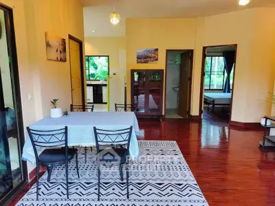Spacious open-plan living area with dining table and hardwood floors
