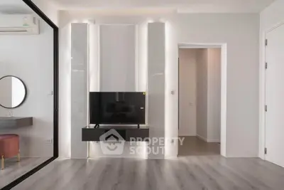 Modern living room with sleek TV setup and stylish decor, featuring elegant lighting and contemporary design.