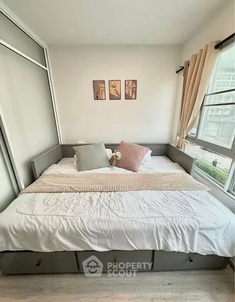 Cozy bedroom with large window and stylish decor in modern apartment.